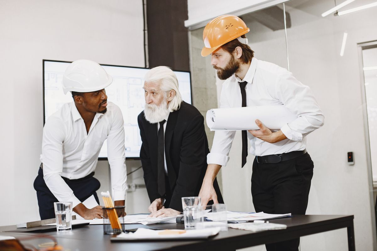 Equipe técnica revisando uma planta de projeto.