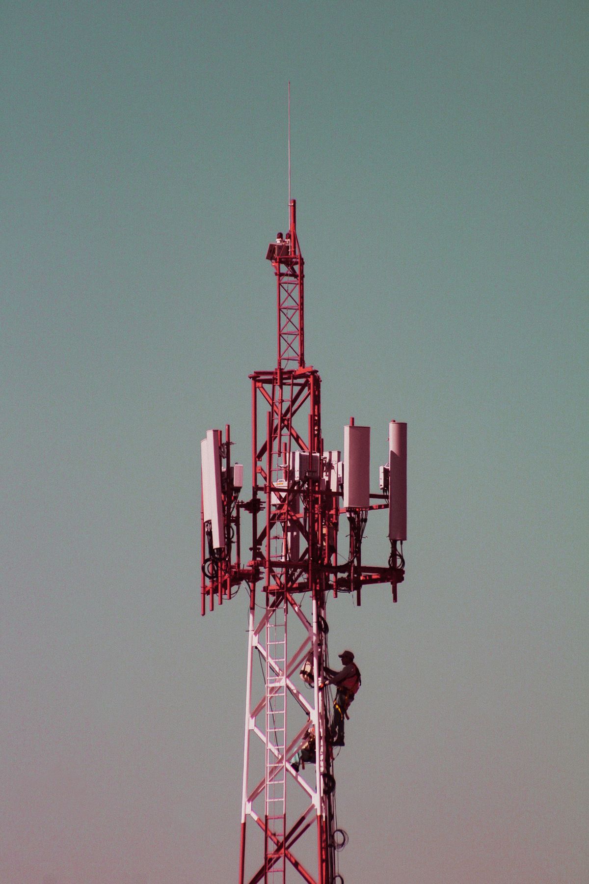 Técnicos trabalhando em torre de telefonia celular.
